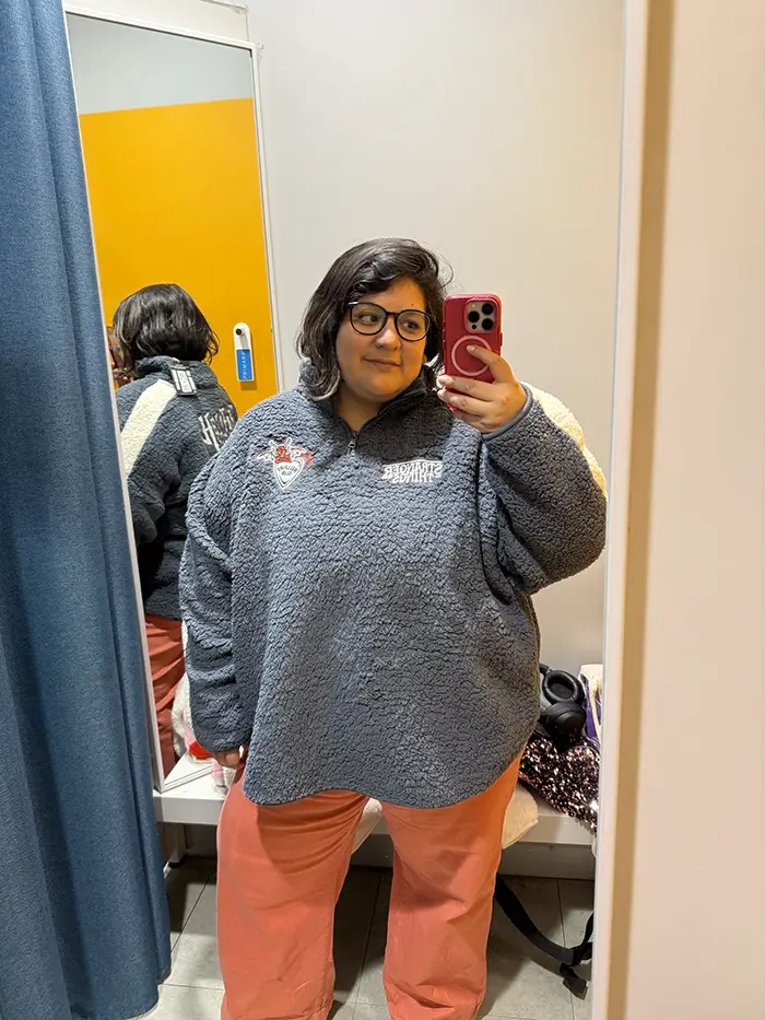 Pull polaire Stranger Things Primark en 2XL (gris) porté en cabine, associé à un pantalon corail.